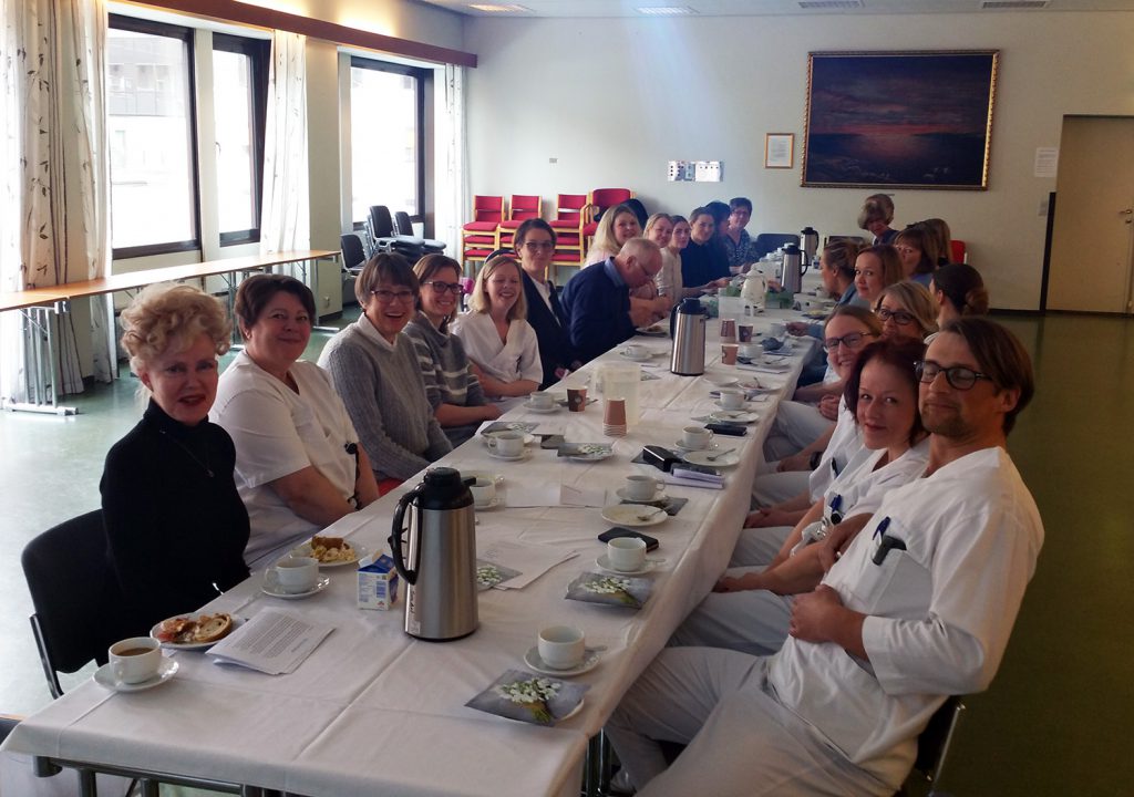 En gruppe mennesker som sitter ved et bord og spiser mat