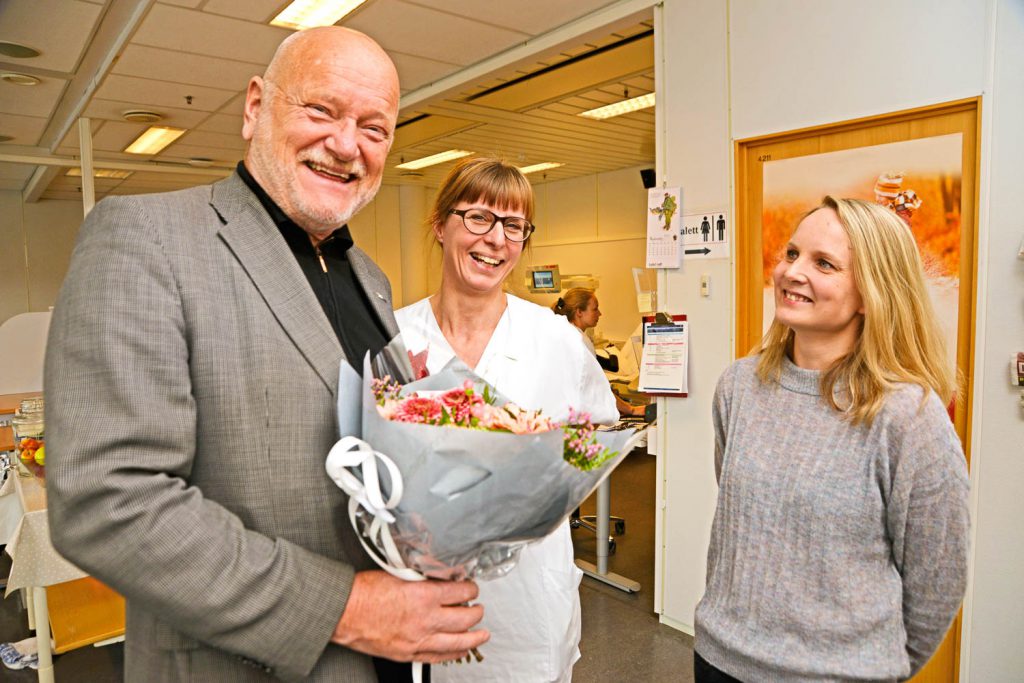 En mann som holder en blomsterbukett og en kvinne som holder en bukett