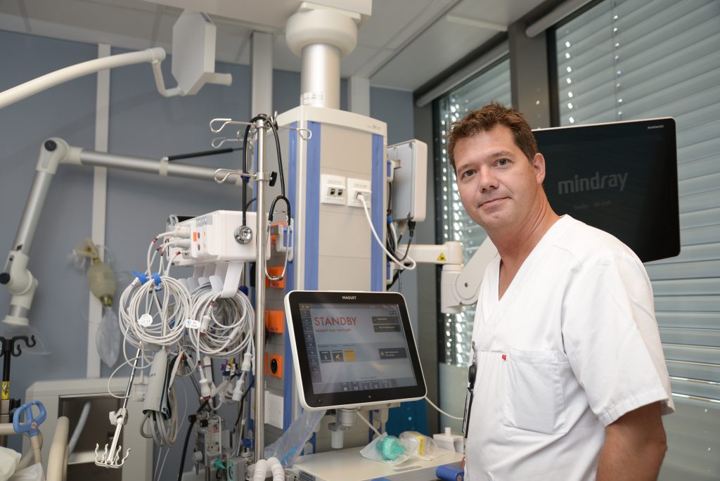 En mann som står i et rom med en datamaskin og utstyr