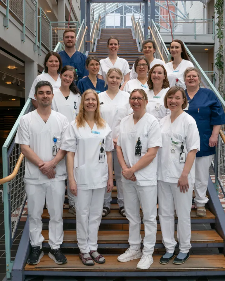 Seksten mennesker som står i en trapp