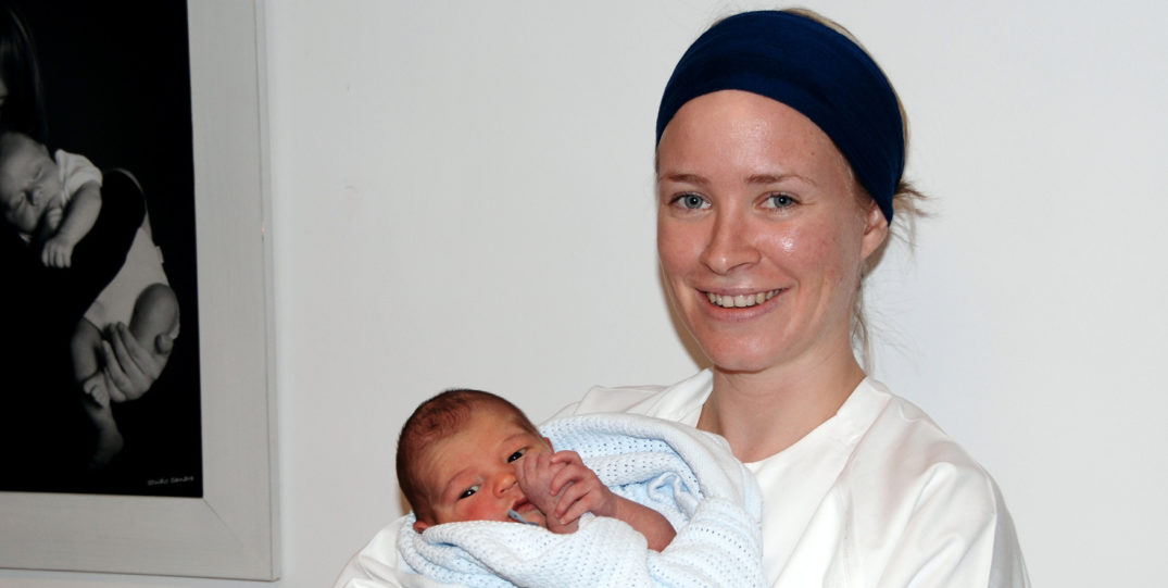 En kvinne som holder en baby