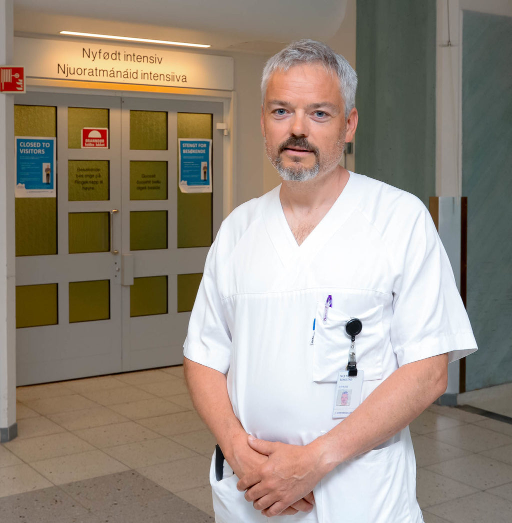 En mann iført hvit frakk