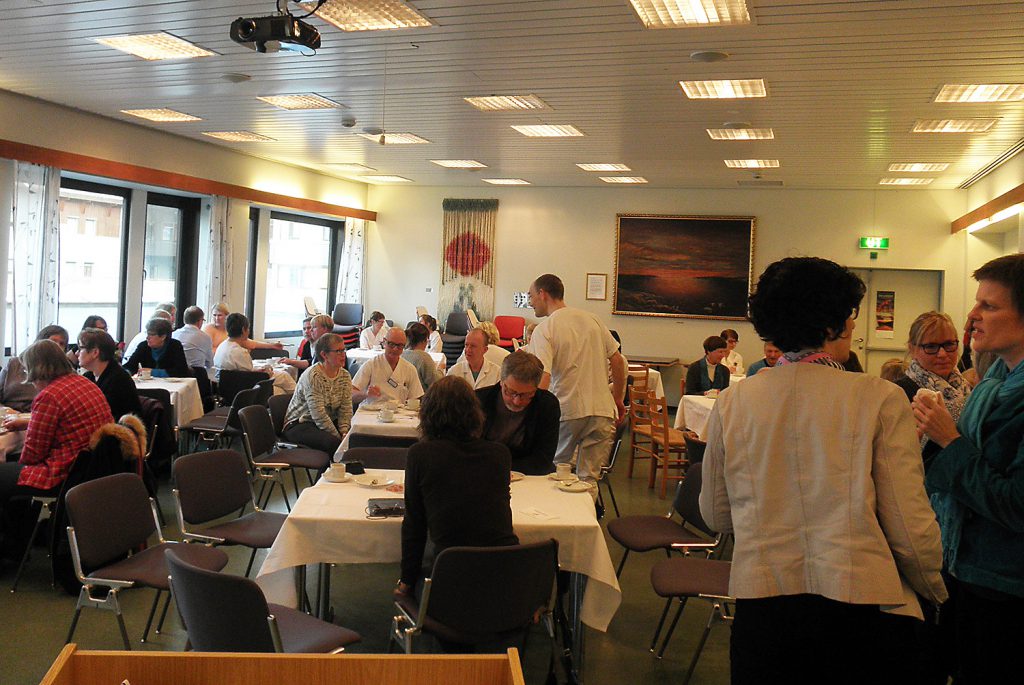 En gruppe mennesker som sitter ved bord