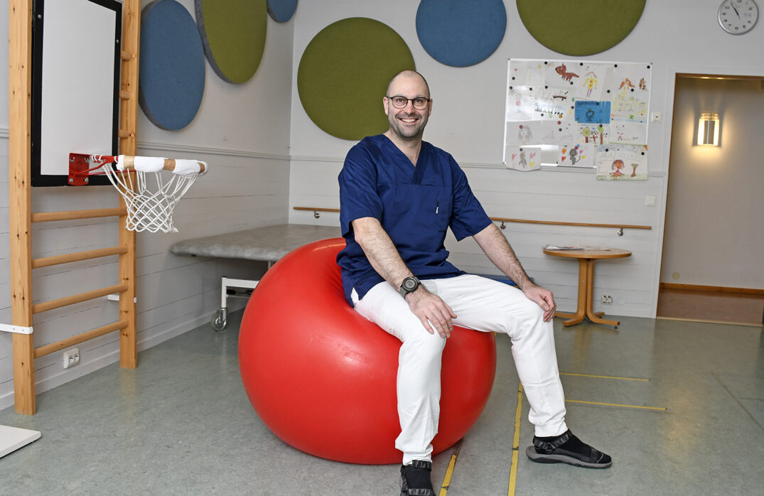 Jeffrey Lewis sittende på ball inne på barnehabiliteringa