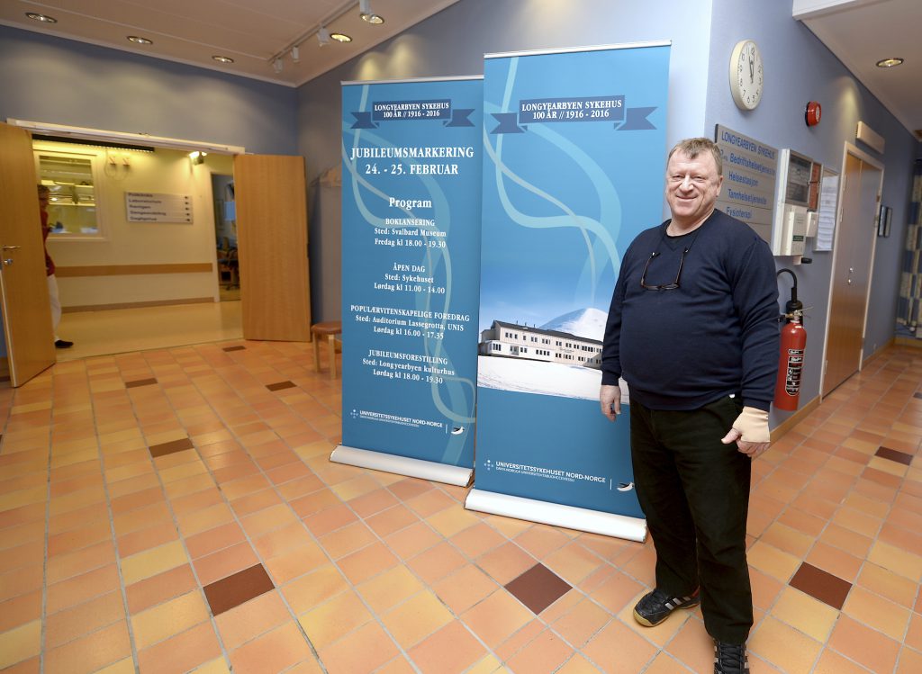 En mann som står ved siden av et skilt