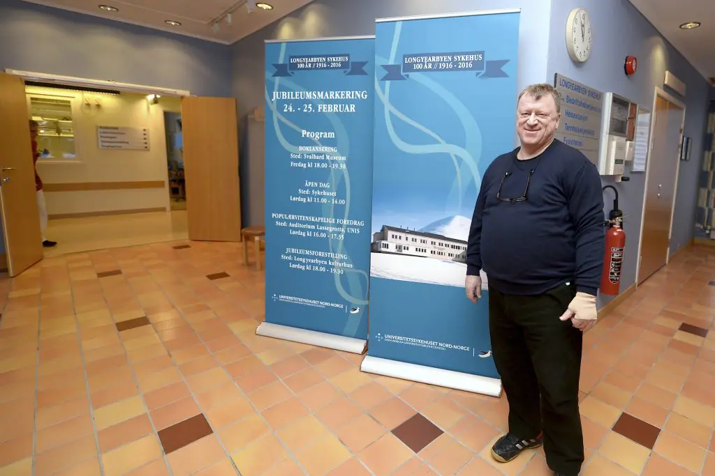 En mann som står ved siden av et skilt