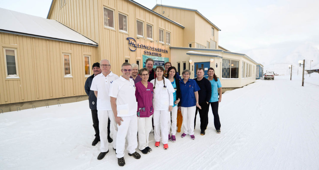 En gruppe mennesker som poserer for et bilde i snøen