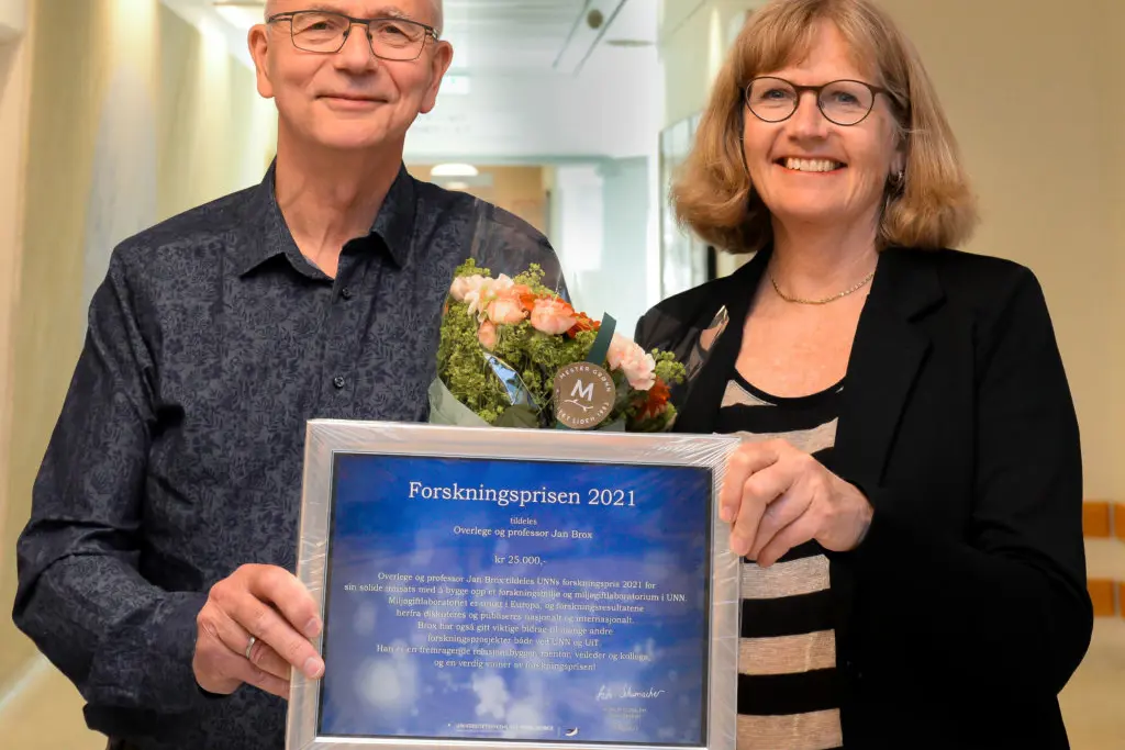 En mann og en kvinne holder en plakett