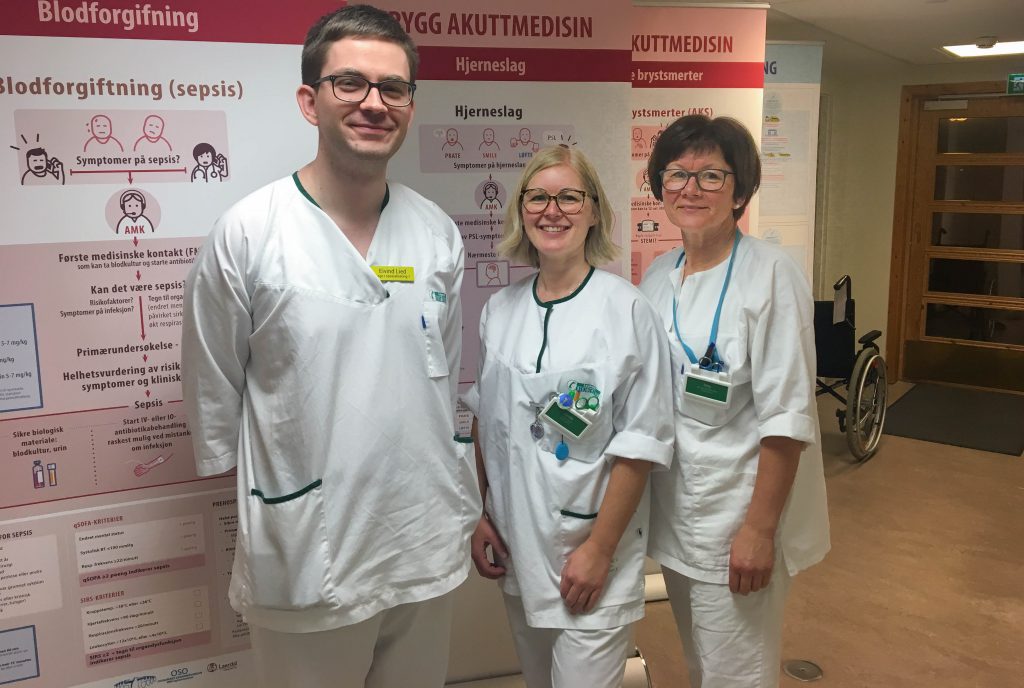 En gruppe mennesker iført hvite laboratoriefrakker og merke