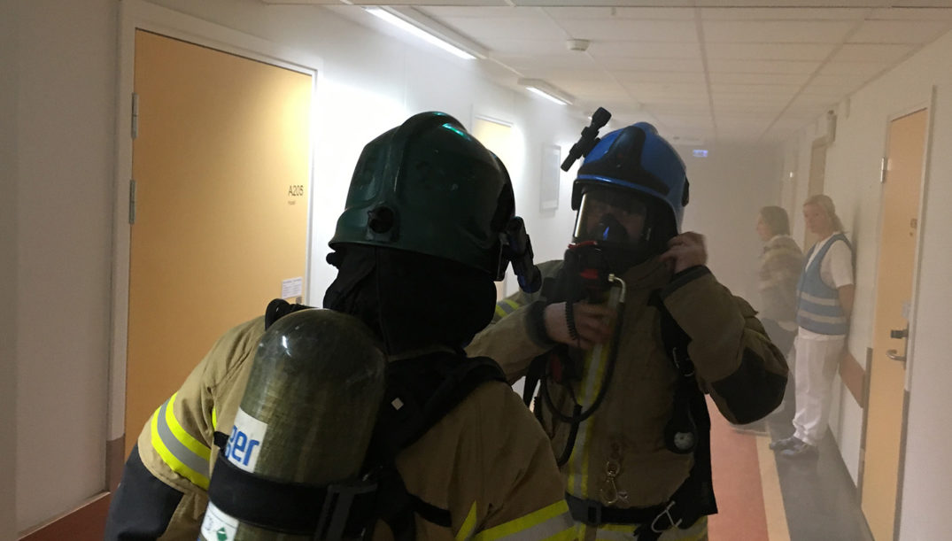 Et par brannmenn i en korridor