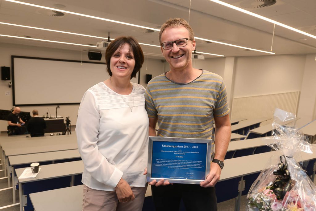 En mann og en kvinne holder en plakett