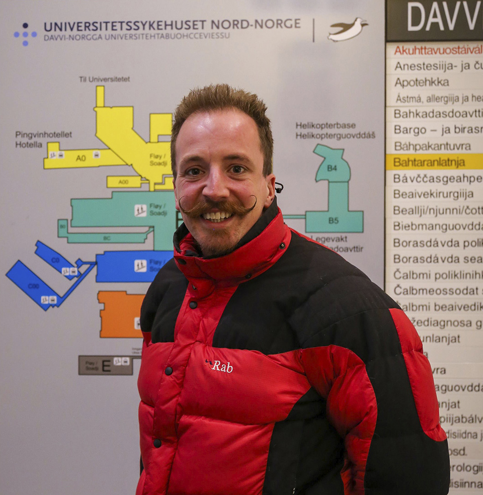 En mann som smiler til kameraet