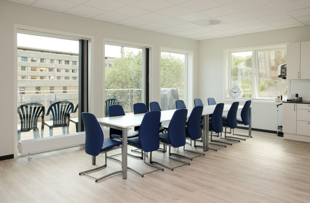 Et rom med bord, stoler og vindu