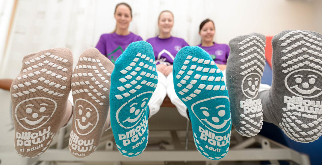 En gruppe mennesker som sitter på en benk med føttene opp