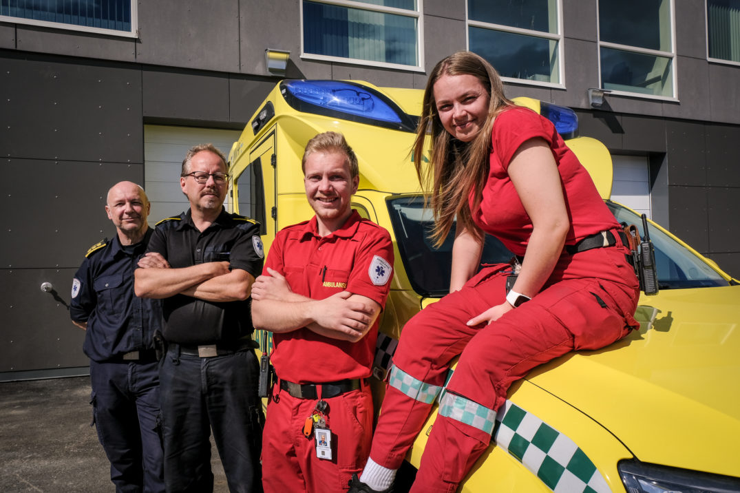 En kvinne i et rødt plagg står ved siden av en mann i et gult plagg