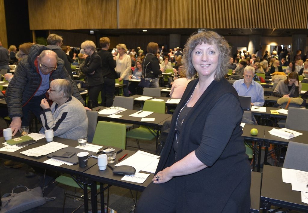 En person som står i et rom fullt av mennesker