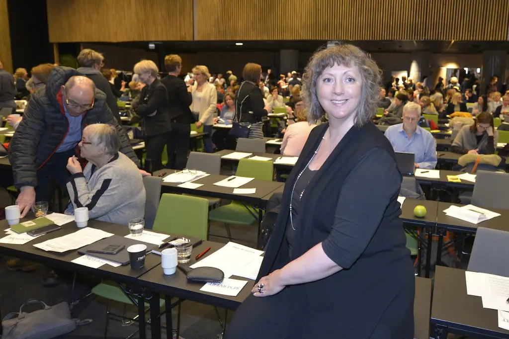 En person som står i et rom fullt av mennesker