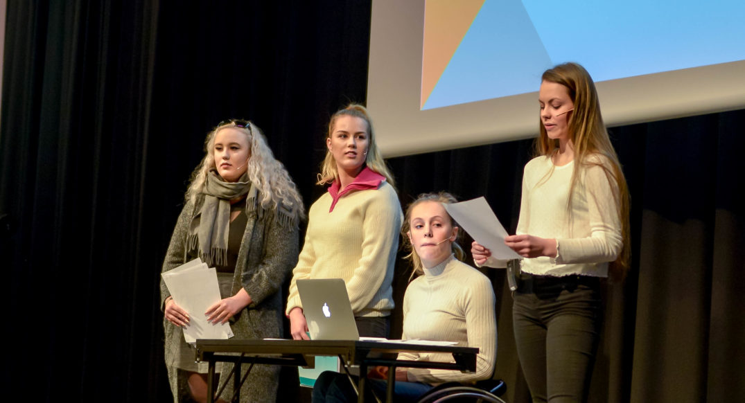 En gruppe kvinner som står foran en bærbar PC