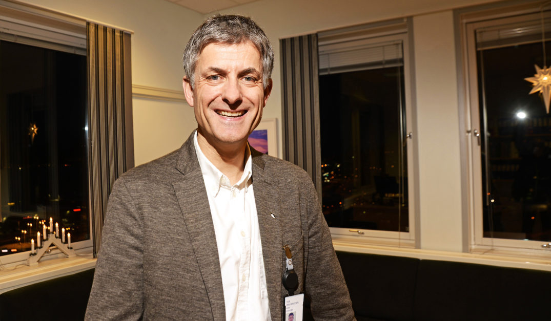 En mann som smiler til kameraet