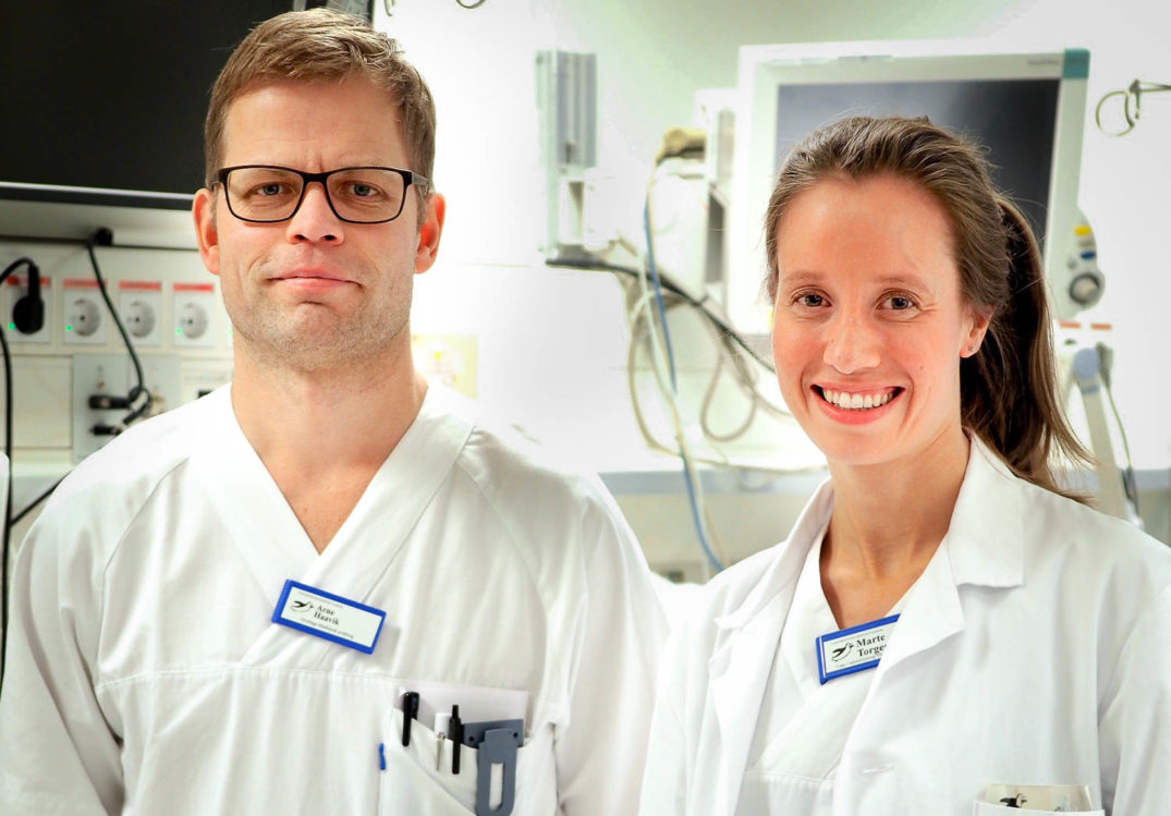 En mann og en kvinne i hvite laboratoriefrakker