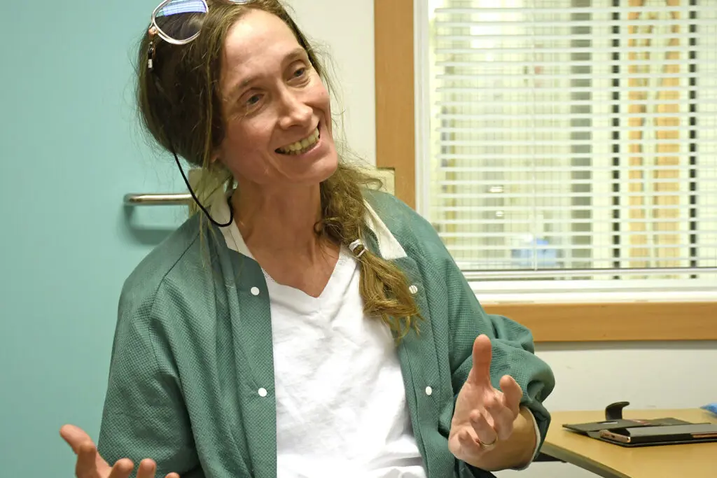 En kvinne som smiler og peker