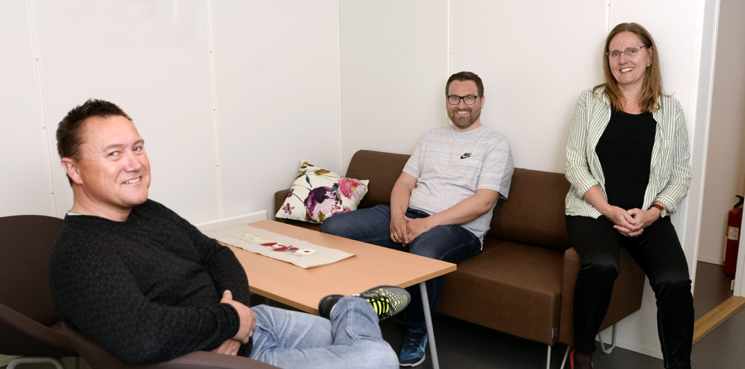 En gruppe mennesker som sitter i en sofa