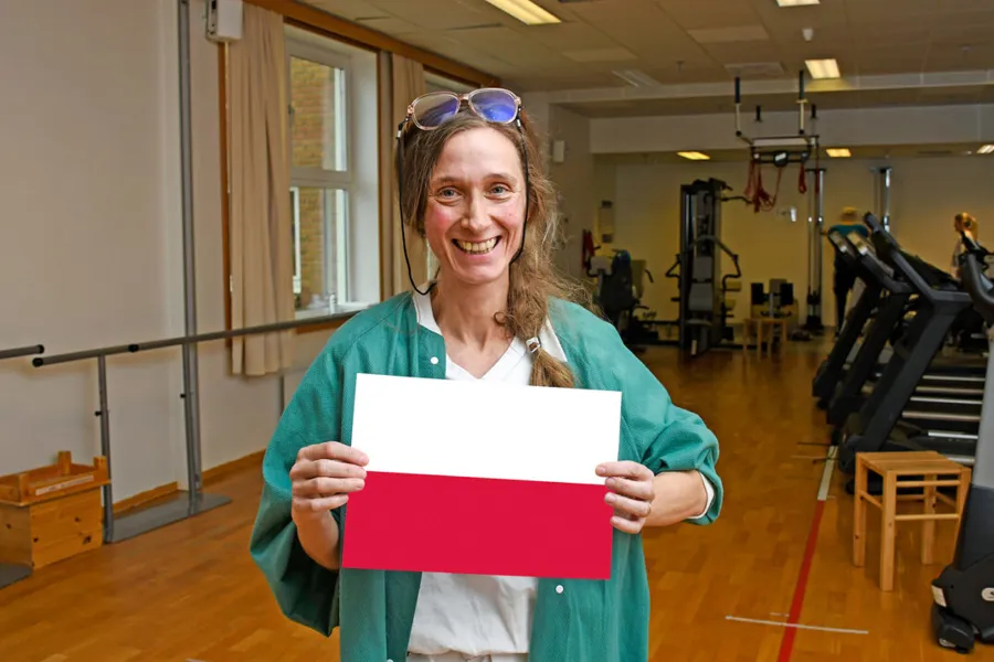 En kvinne som holder en rød og hvit mappe