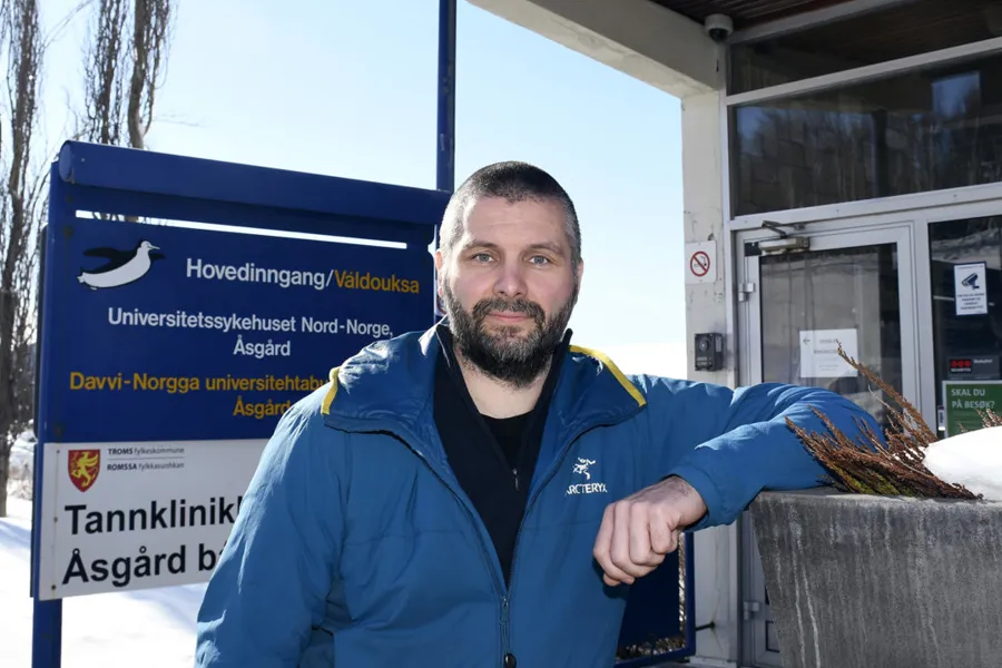 En mann som står foran et skilt