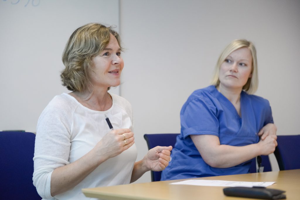 Et par kvinner som sitter ved et bord