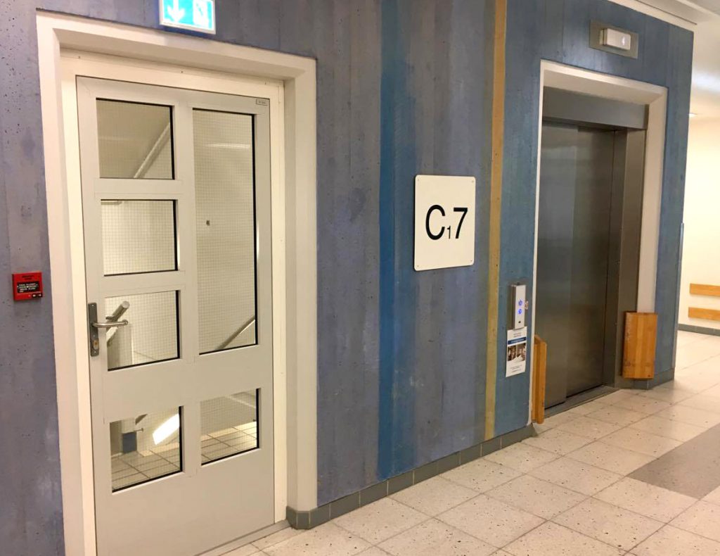 En blå bygning med et skilt på døren