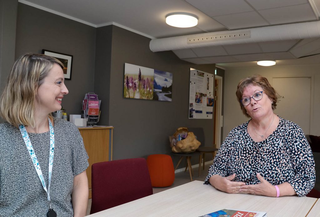 Et par kvinner som sitter ved et bord