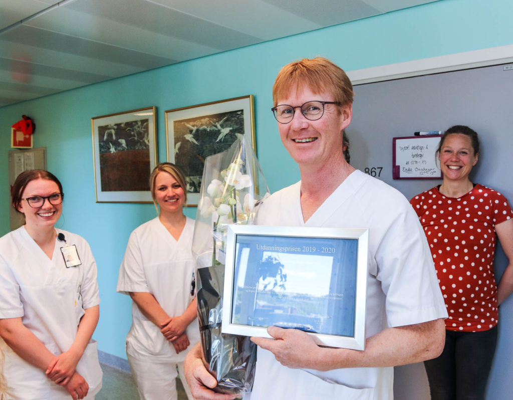 En gruppe mennesker som holder et innrammet bilde