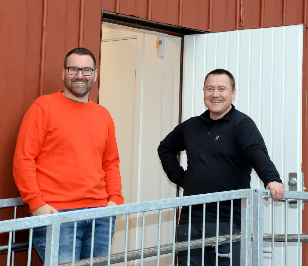 To menn som står ved et rekkverk