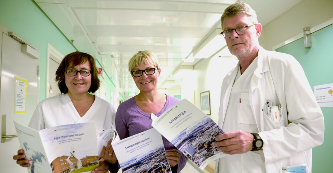 En gruppe mennesker som holder papirer