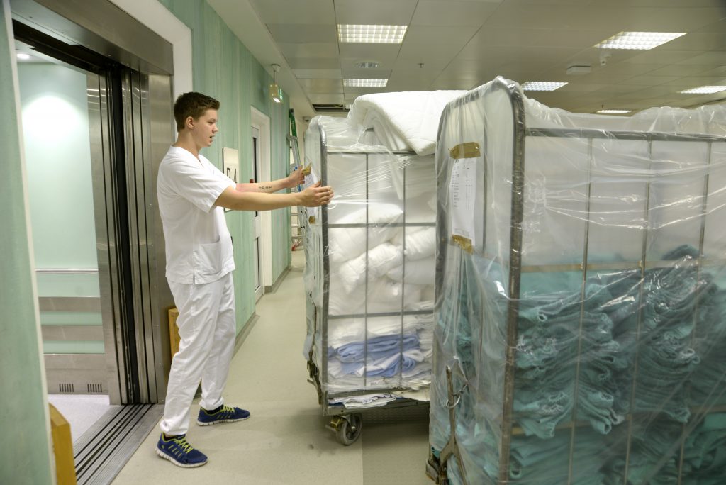 En mann som skyver en vogn full av klær