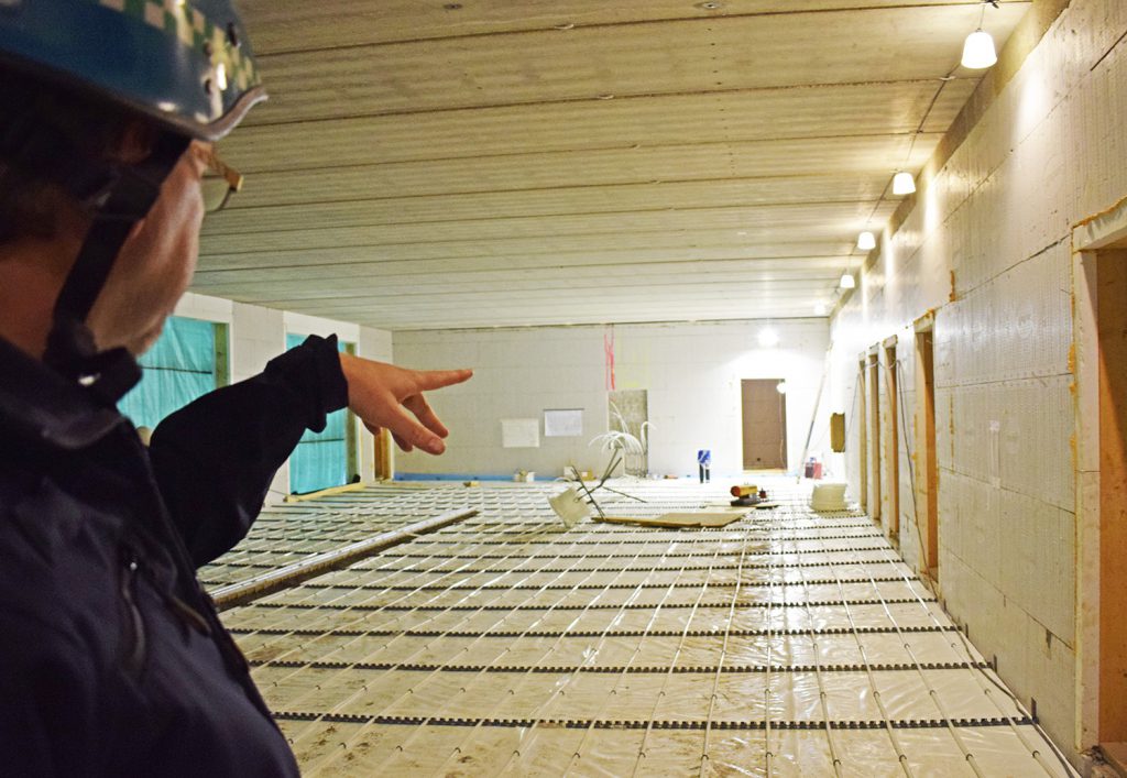 En mann med hjelm som ser på et stykke tre