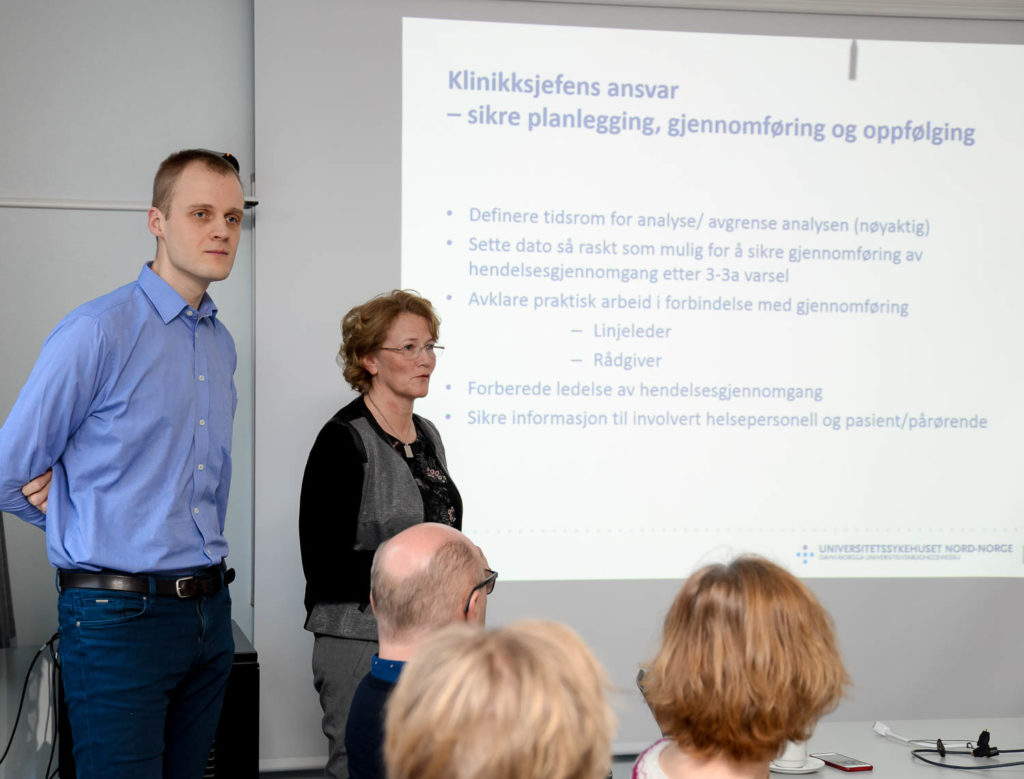 En mann og en kvinne står foran en whiteboard