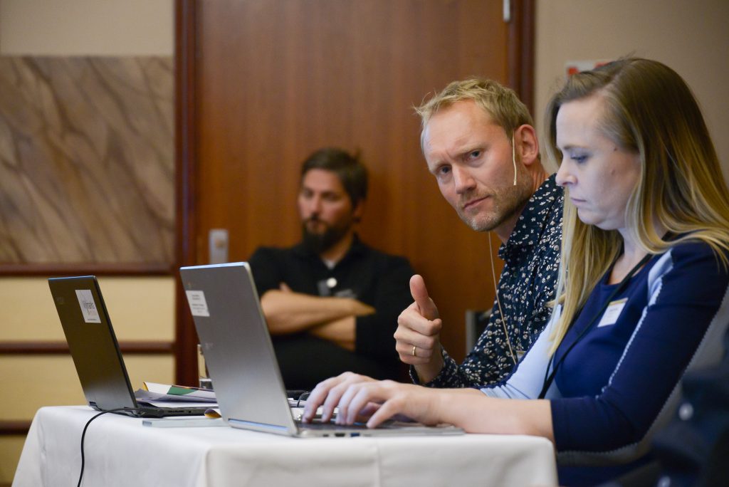 En gruppe mennesker som sitter ved et bord med bærbare datamaskiner