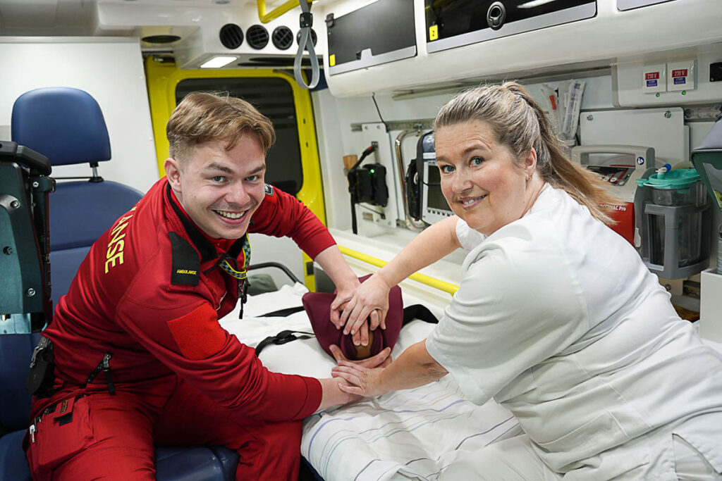 Paramedisiner og jordmor simulerer fødsel bak i ambulanse