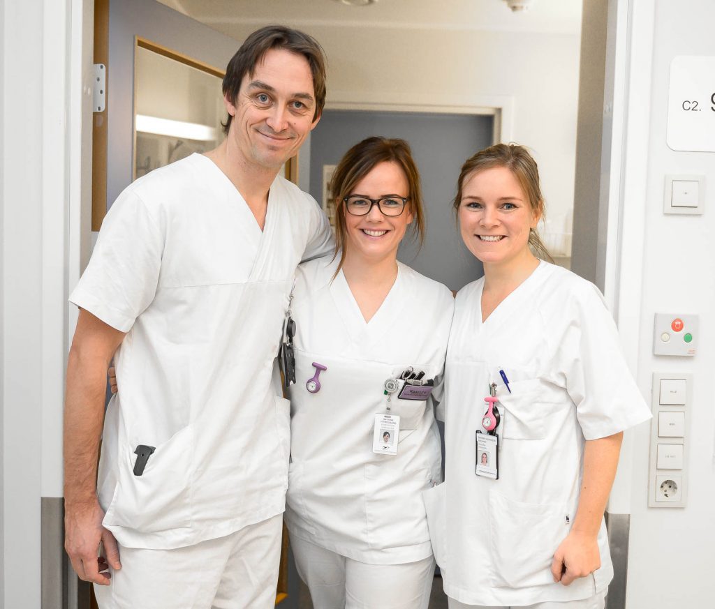 En gruppe mennesker iført hvite laboratoriefrakker