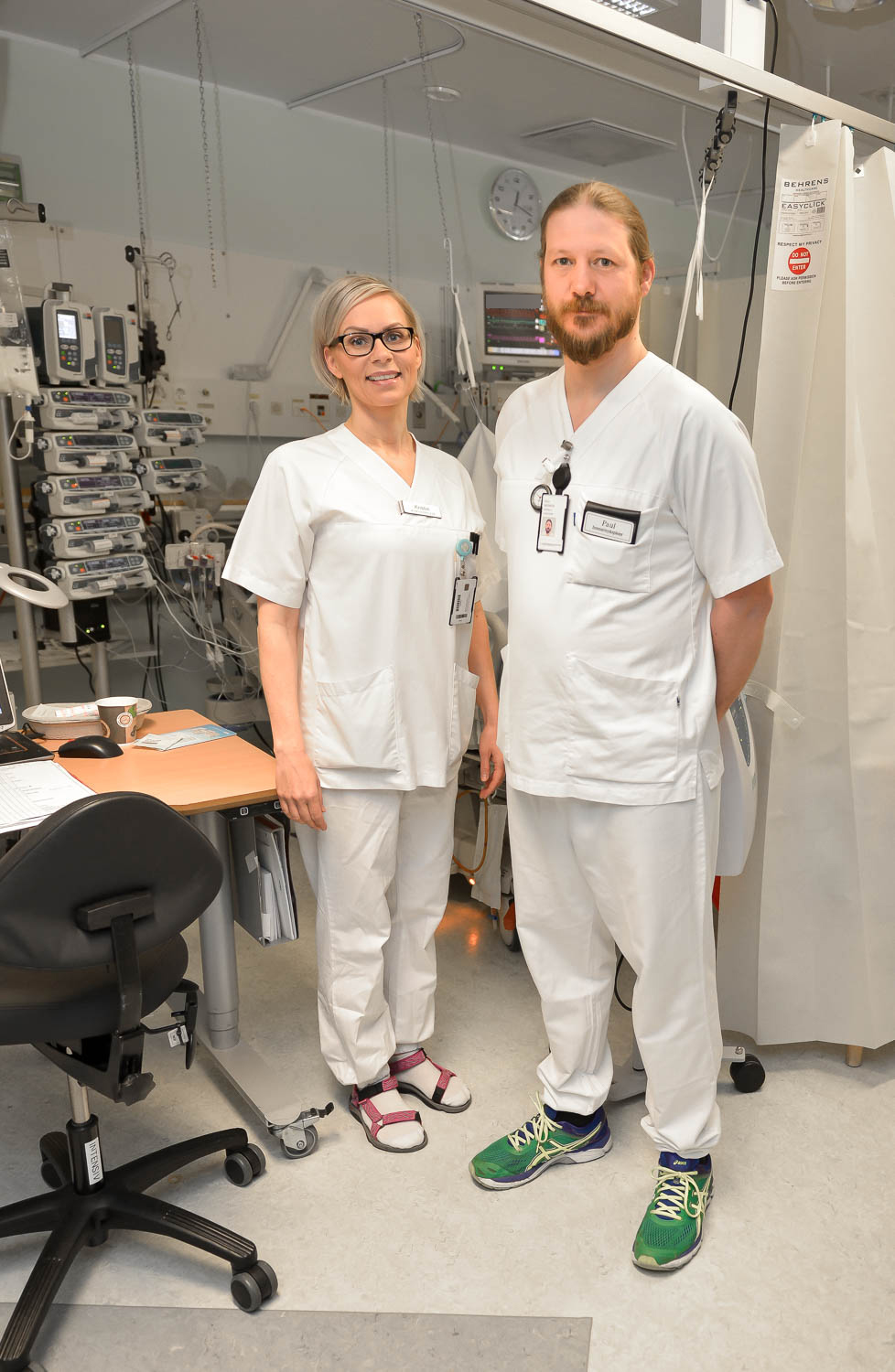 En mann og en kvinne i hvite laboratoriefrakker står i et rom