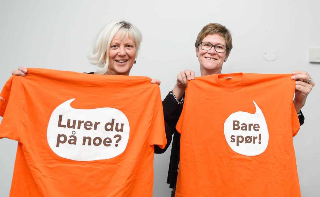 En mann og en kvinne holder opp et skilt