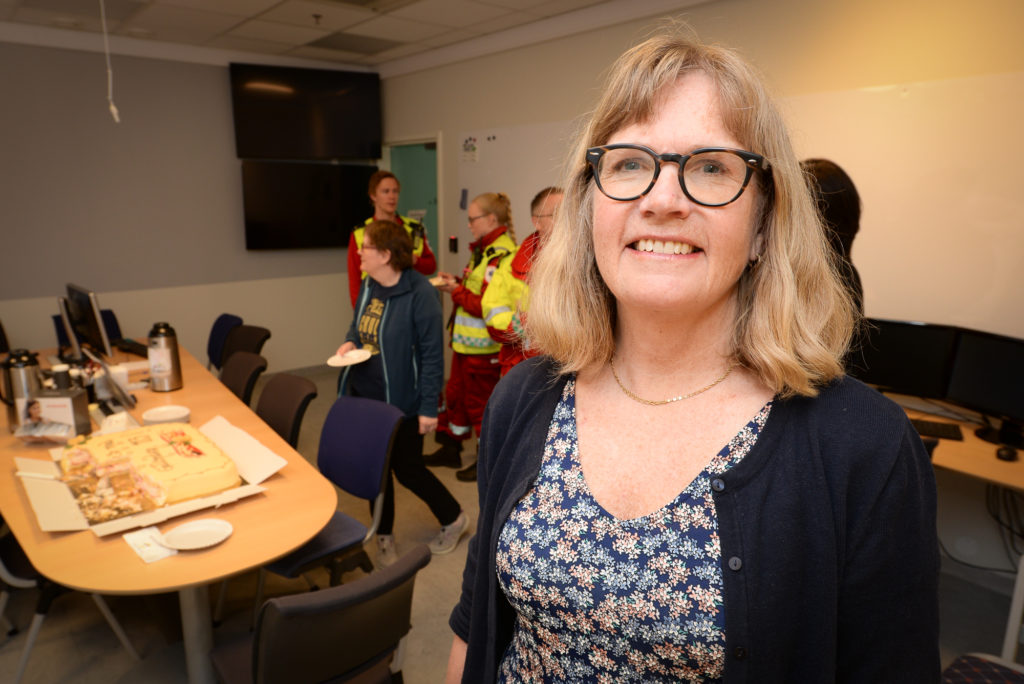 En kvinne som smiler til kameraet