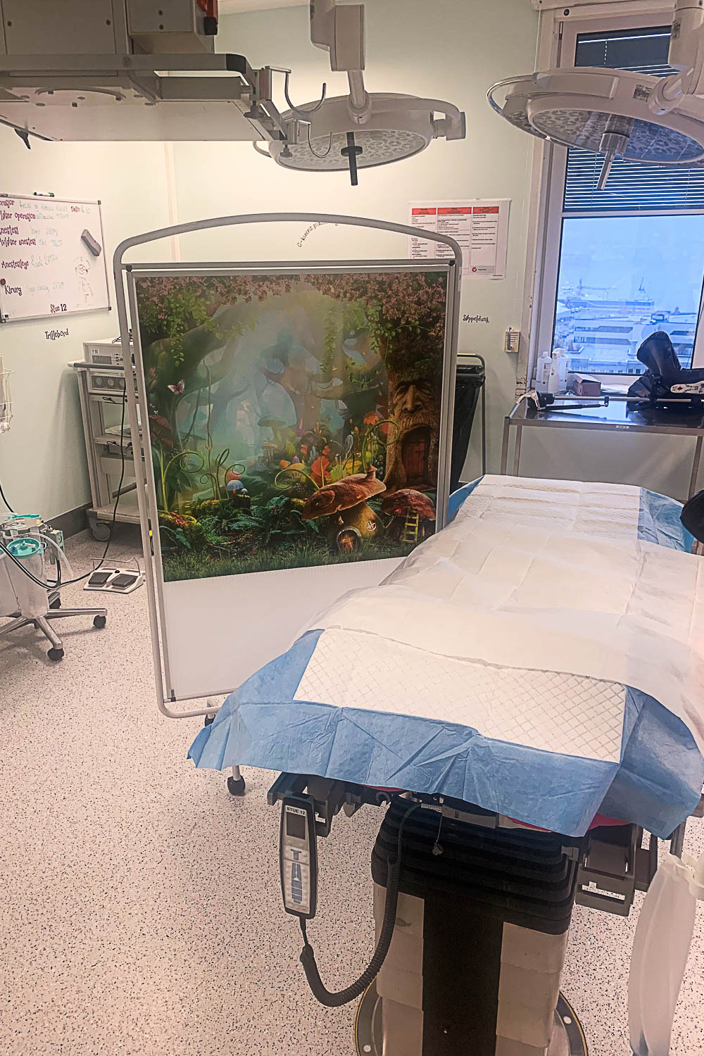 Operasjonssal med seng og en fargerik skillevegg