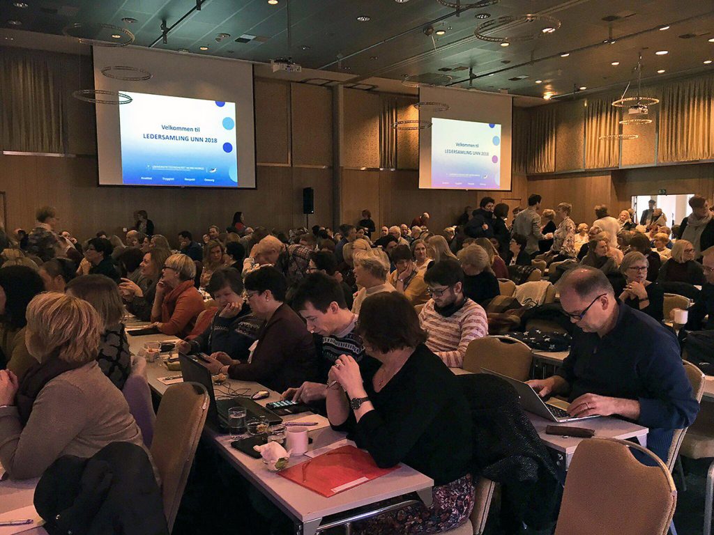 En gruppe mennesker som sitter i et konferanserom