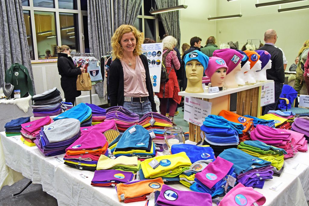 En person som står ved siden av et bord fullt av klær