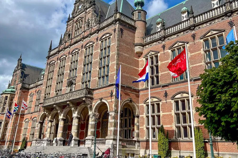 En stor murbygning med flagg foran