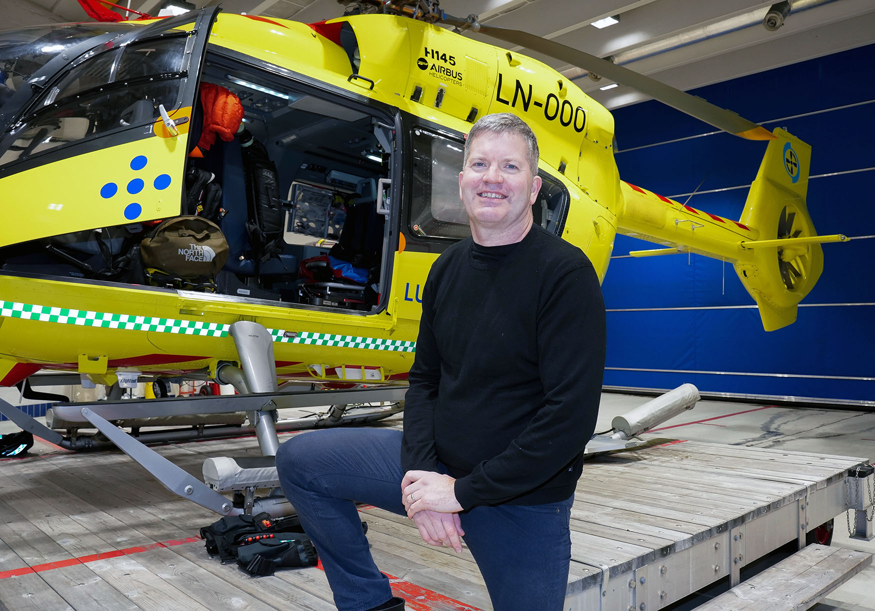 En person som står foran et gult helikopter