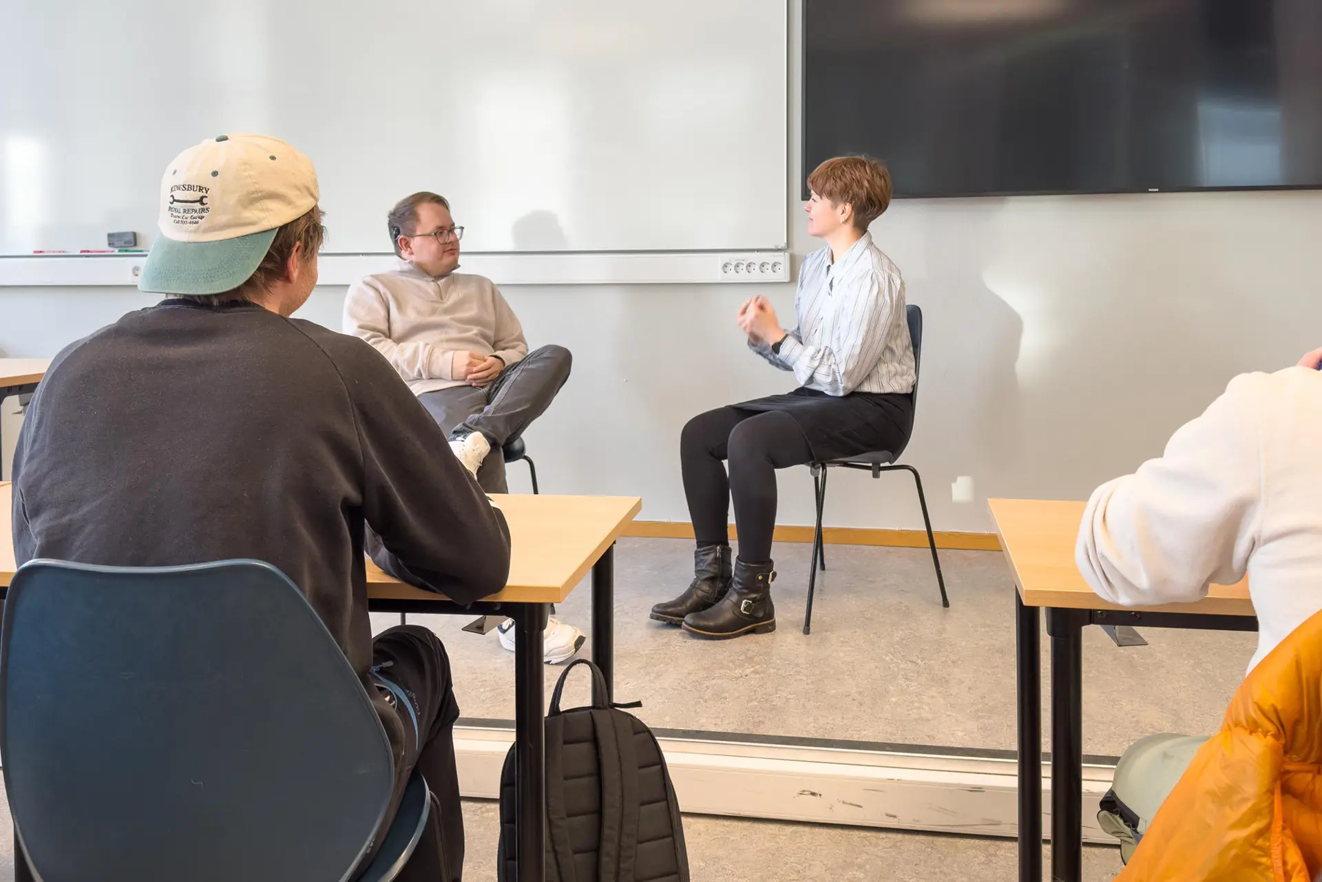 Fire mennesker som sitter i stoler