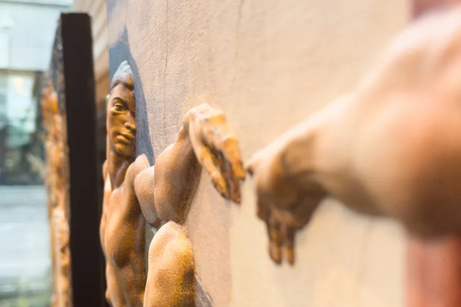 Steinbilde hvor to hender berører hverandre